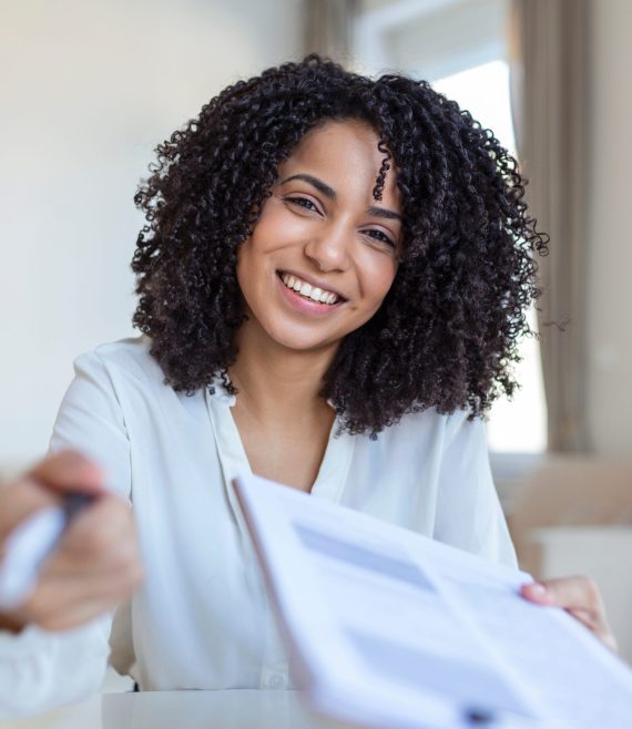 Sign,Here.,Young,Smiling,Confident,Woman,Pointing,To,A,Contract,